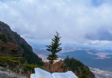 Open Bible resting on a rock overlooking mountains